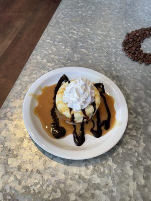 New York style cheese cake topped with caramel and chocolate sauce and whipped topping.  Yummy!