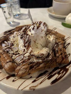 Churros with vanilla ice cream and chocolate syrup.