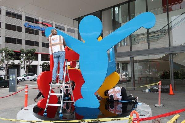 Cleaning, polishing and inpainting a Keith Haring sculpture in San Francisco.