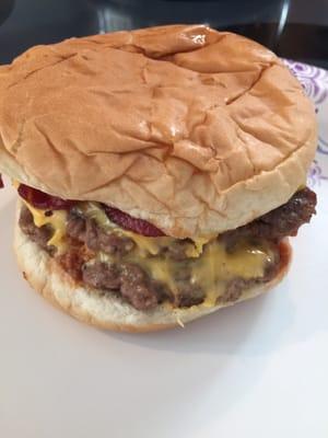 Double cheeseburger with onions bacon and chili.