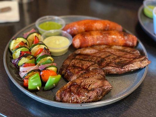 Picanha Steak Plate with extra sausage and grilled vegetables. Cooked medium-rare.