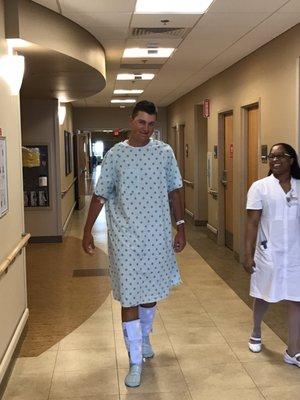 Sweet nurse on staff walking with him after post surgery. Every nurse/doctor/technician was this great