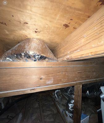 Shoddy ductwork squeezed in between the roof and support beam.