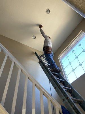 Jesus Jaime installing upper level chandelier.