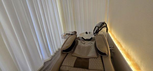 full body massage chair with the sink in a private curtain-closed area