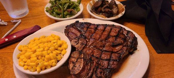 My entree the porter house t bone cooked medium well with the side of corn and green beans and the onions and mushrooms to go on the  steak.