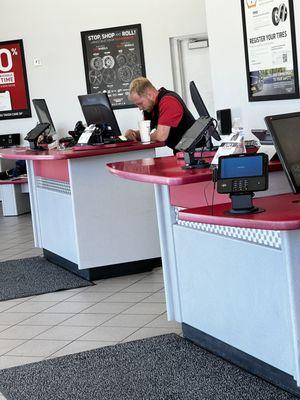 Manager sipping on his drink scrolling his phone while a single young employee does all the work in the entire shop.