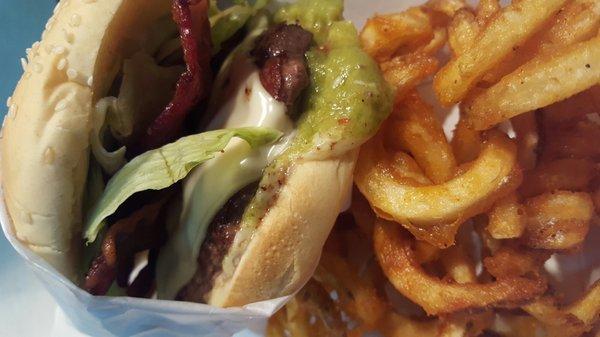 Guacamole bacon burger with curly fries.