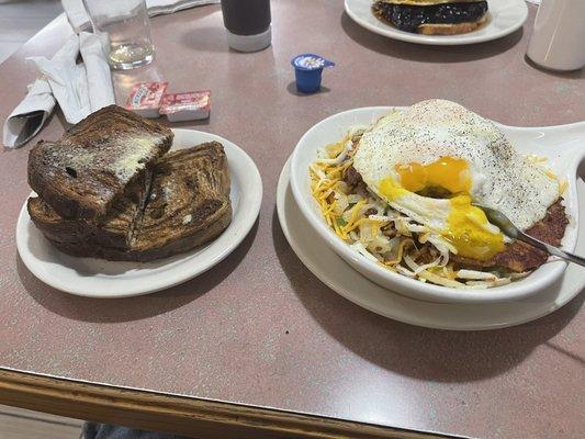 Corned Beef hash skillet with two eggs over easy and 2 pieces of marble rye toast with butter.