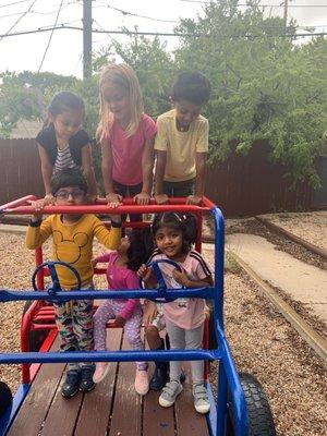 Outside on the playground which is has lots of shade.