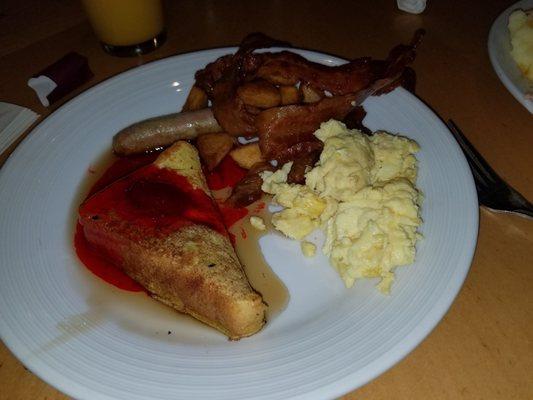 French toast with strawberry topping, potatoes, bacon, sausage, scrambled eggs