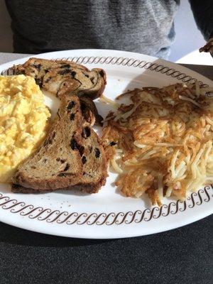 Cheesy eggs, raisin toast and hash browns.