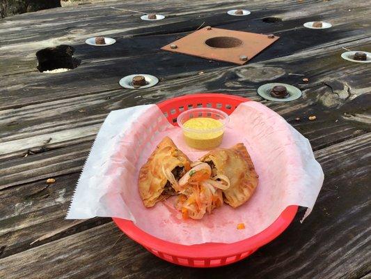 Ground beef and peruvian spices empanada with criolla sauce and huancaina deep