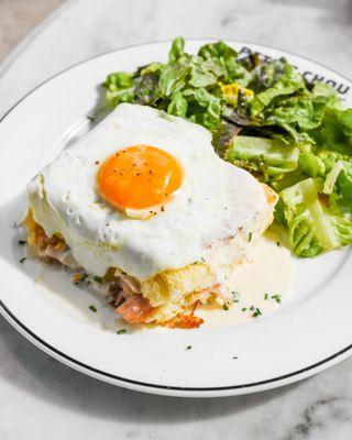 Croque Madame: Thinly sliced ham, gruyère, mornay, chives, topped with an egg and served with a side of lightly dressed greens!