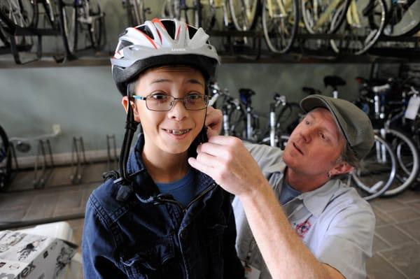 Rick fitting a helmet on a young rider.