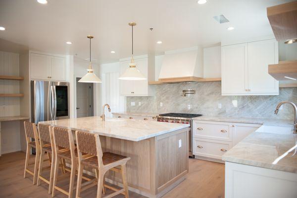 White Oak accent island, Taj Majal Quartzite countertop with a full backsplash. What do you think about that pot filler & custom hood range?