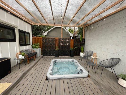 Fully covered hot tub area, seating, and just to the left is the room with AC, kitchenette, bathroom/shower.