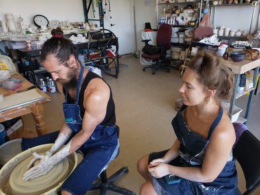 Students Learning How To "Throw" Pottery On The Wheel.