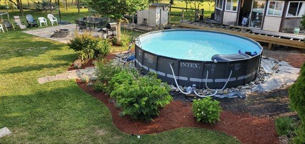 patio, stone walkway,  pool installation  with nice plants and red mulch