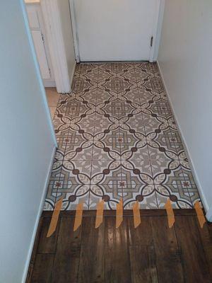 Small hallway tile job. With decorative tile. A repair to replace damaged wood floors.