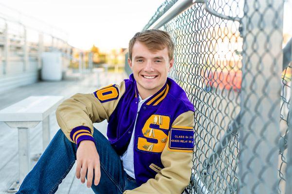 Senior boy, letter jacket at the football field