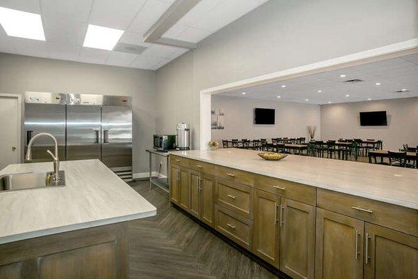 Kitchen with refrigerator, freezer, microwave and coffee percolator.