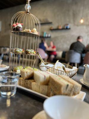 Egg, strawberry,cucumber and avocado sandwich  and scones at the back with their cream and dessert on platters