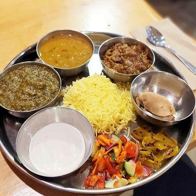 thali plate with eggplant, rice, nann bread, dall which is bean, and pickled  onions and peppers, vegab yogurt