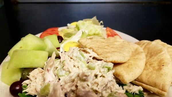 Tuna salad plate; tuna salad, lettuce, tomatoes, grapes, honydew, hardboiled egg, and pita bread.