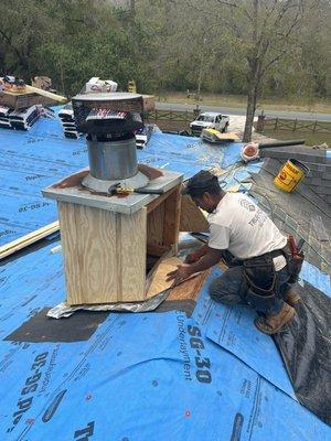 Rebuilding a chimney and installing a cricket to divert water from pooling behind the chimney.