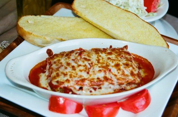 Lasagna made with ricotta cheese and served with garlic bread