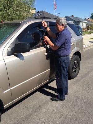 Customer locked keys in car. Business owner opening the vehicle.