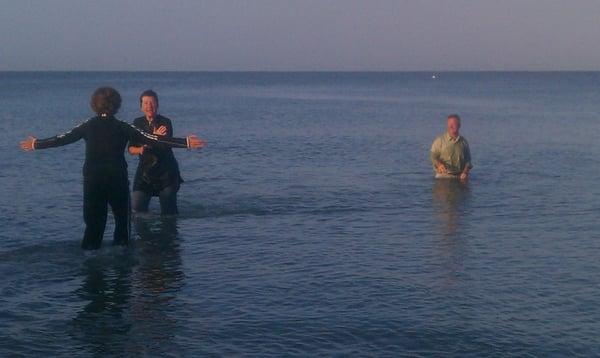 One happily baptised,.  Another of the faithful enters the Gulf for baptism