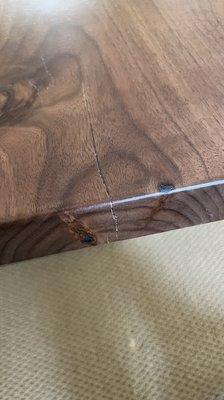 Crack at edge of table going down to under side of table and across the top