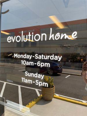 Hours on the front door of Evolution Home