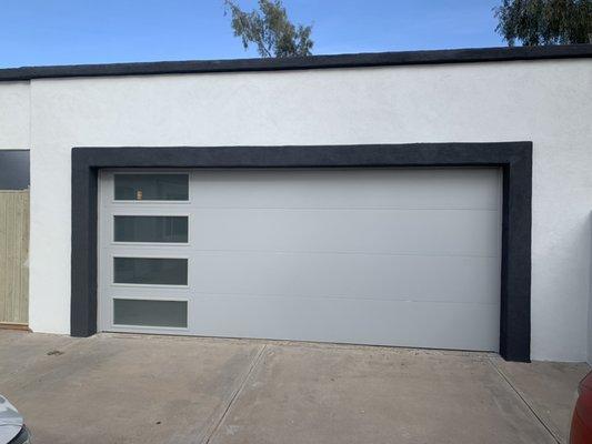 This is a modern steel door has  tempered frosted glass going down one side of the door.