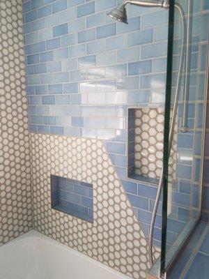 Specialty tile installation and a window cut into the shower bring style and light to this shower.