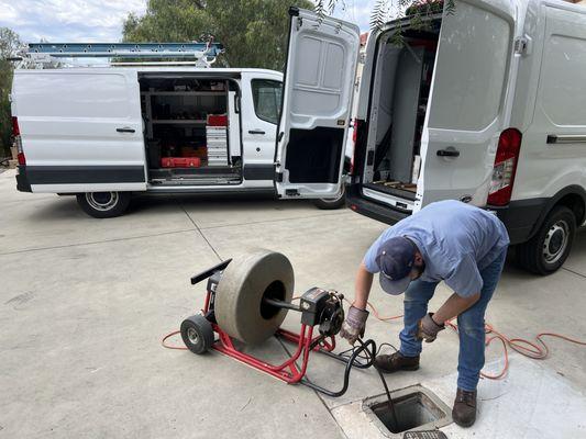 Snaking clogged sewer line.