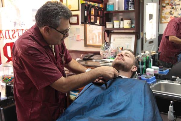 Rafi cleaning up the neck line on a beard.