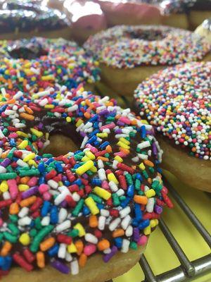 Chocolate donuts with sprinkles on top. We have the big soft ones and the small candies ones.