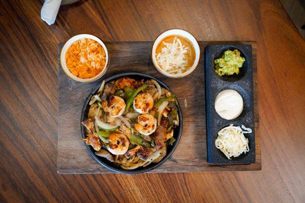 Sizzling Fajitas served with rice, beans, sour cream, grated cheese and tortillas