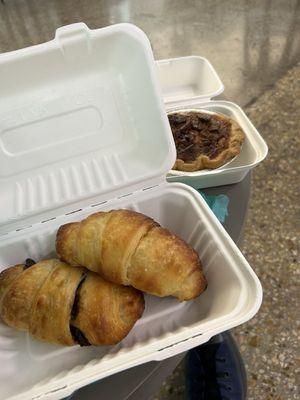 Croissant and chocolate croissant in a recyclable container. And in the back a very delicious pecan pie!