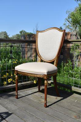 The dining room chairs have been elegantly reupholstered to accentuate the beauty of the wooden frame.