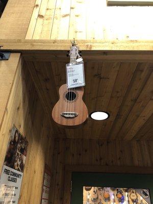 A ukulele hanging on the wall in guitar center