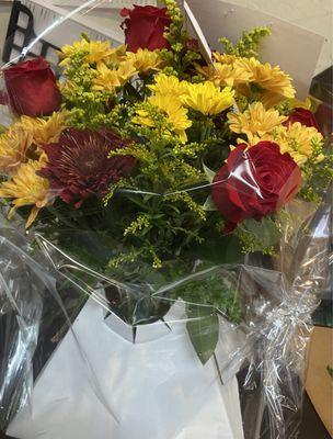 four red roses with flimsy yellow flowers and a burgundy one which is supposed to be a fall flower bouquet this was embarrassing to be sent