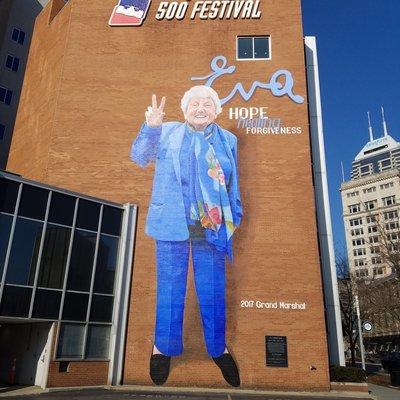 Eva Mozes Kor mural by Pam Bliss 2020.  The mural shares the wall with Carl Leck's 100th Celebration of the Indy 500 mural.