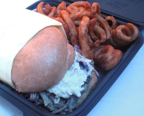 Pulled Pork Sandwich with Cole Slaw and a side of curly fries.