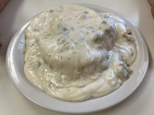 Biscuits with gravy and eggs underneath.