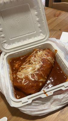 Wet shrimp burrito with red sauce.