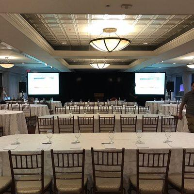 Dual fast fold screens with rear projection with pipe and drape between plus a full sound system for a corporate presentation at a hotel.